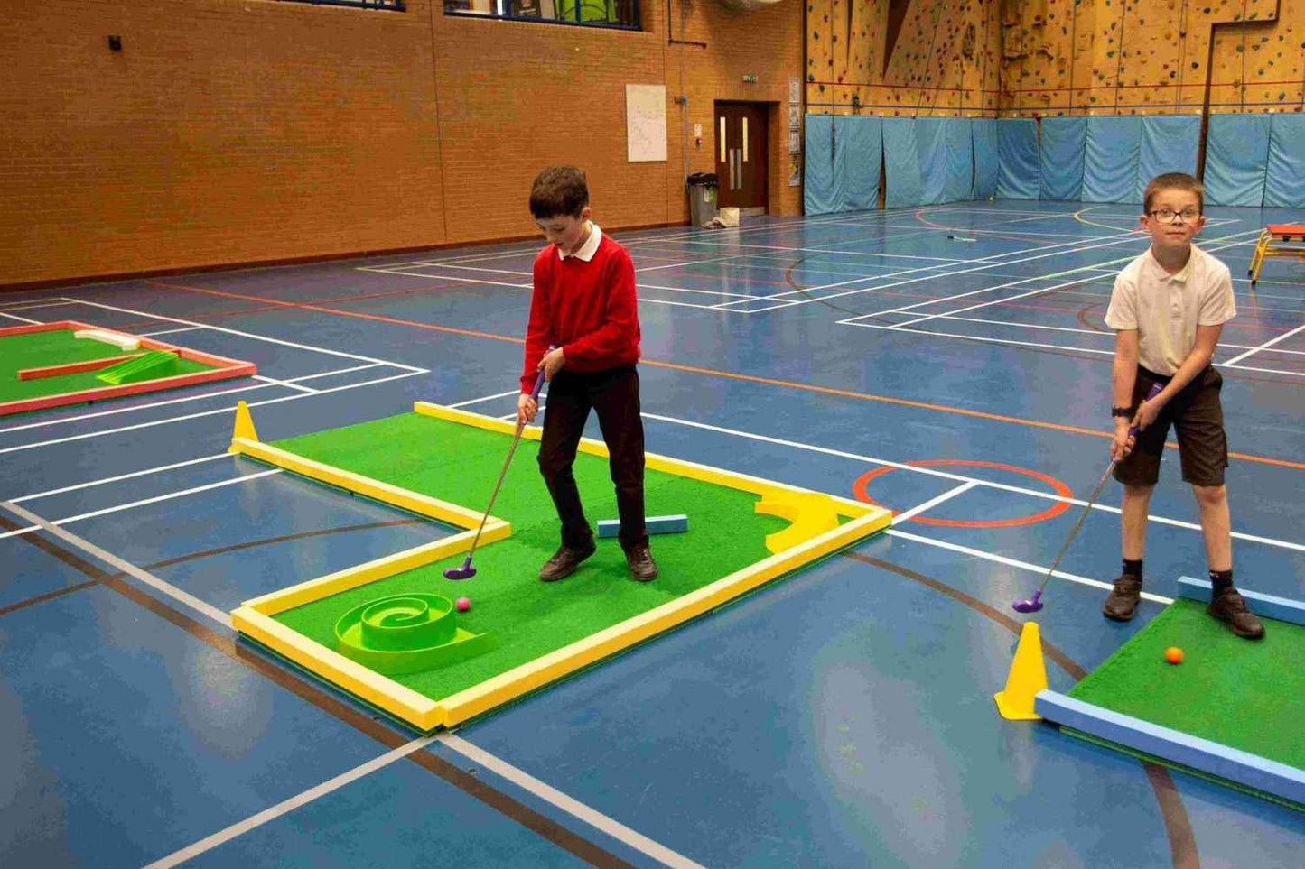 school children playing on funsize mini golf course