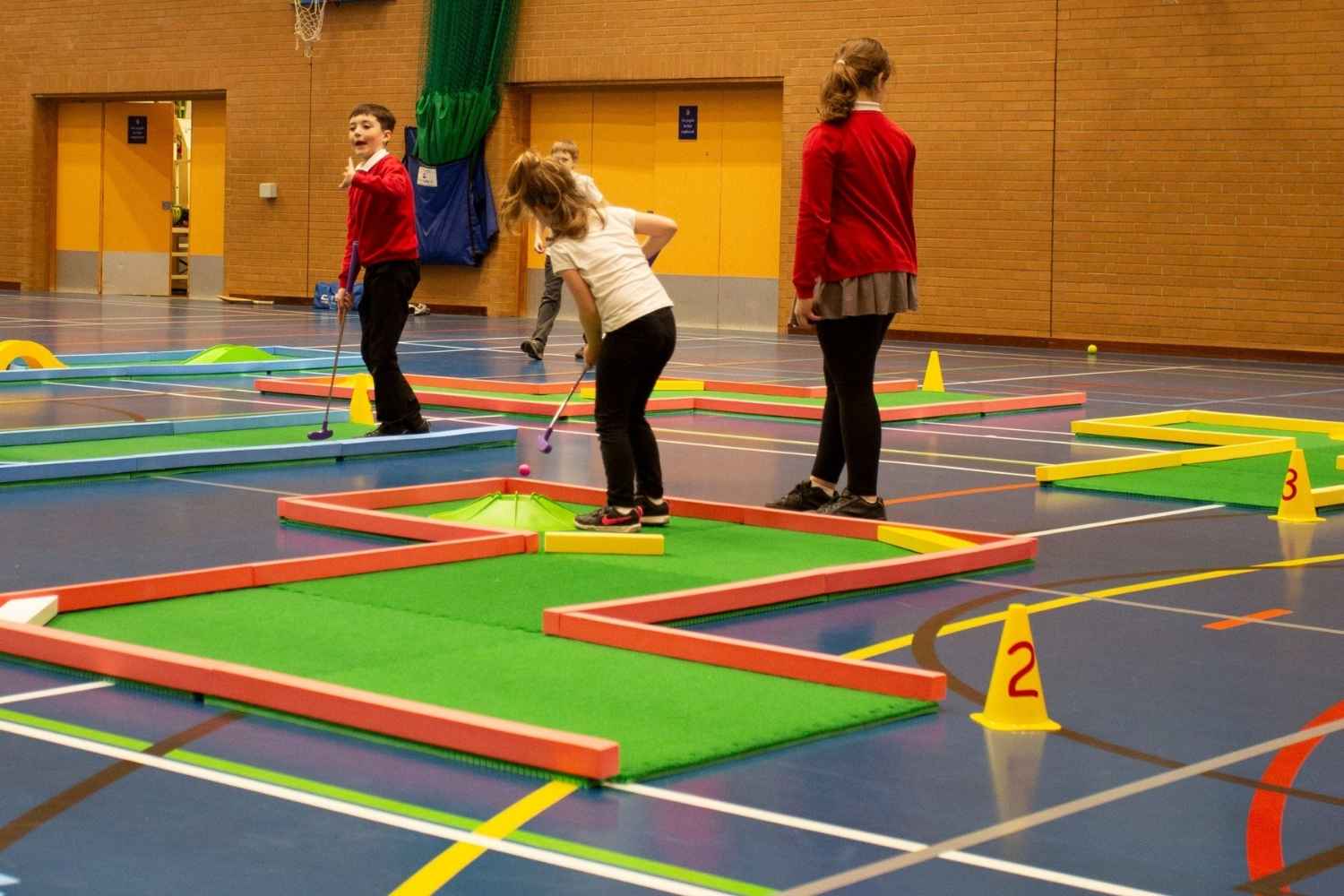 School children playing on supersize mini golf course