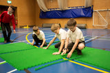 School children putting supersize mini golf course together using interlocking astro tiles