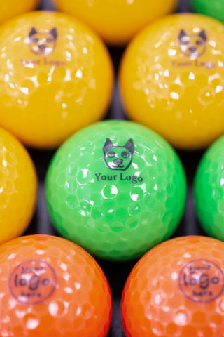 Green 'your logo' mini golf ball surrounded by orange and yellow branded mini golf balls